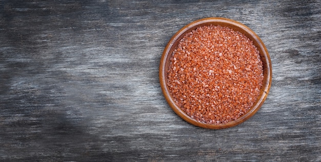 Himalayan red salt in the bowl on a wooden surface