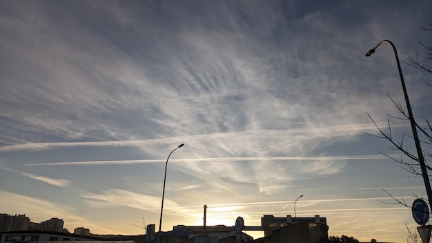 Himtrails in places where planes flew in the sky at sunset over a city in western Europe