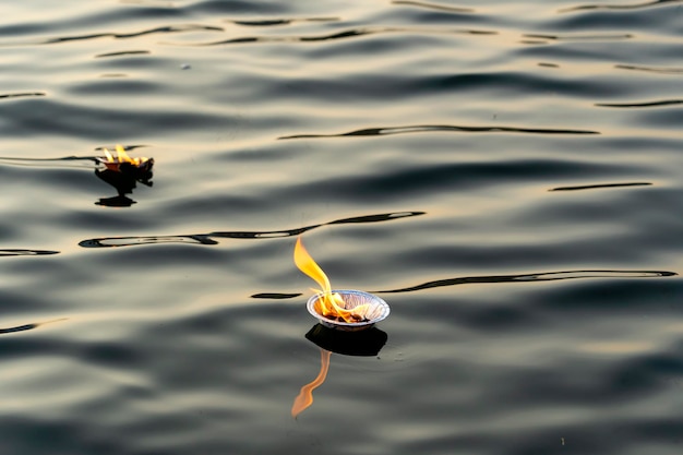 Hinduism religious ceremony puja flowers and candle on river Ganges water India