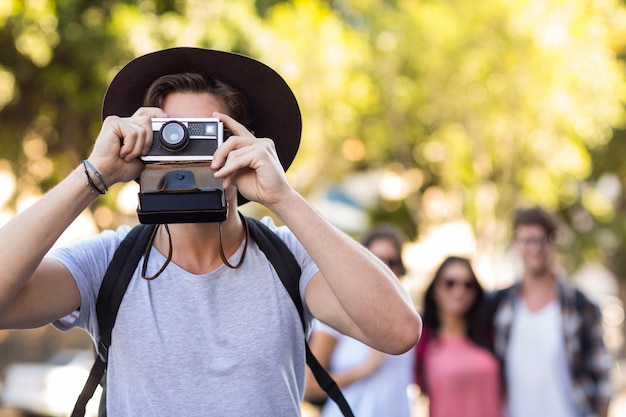 Hip man taking picture with instant camera in the city