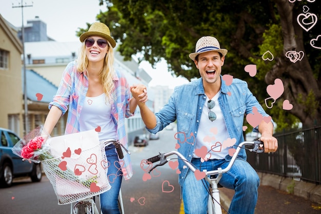 Hip young couple going for a bike ride against valentines heart design