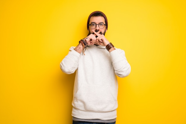 Hippie man with dreadlocks showing a sign of silence gesture