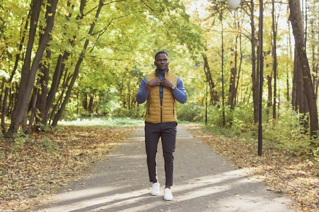 Hipster african american man walking in autumn park