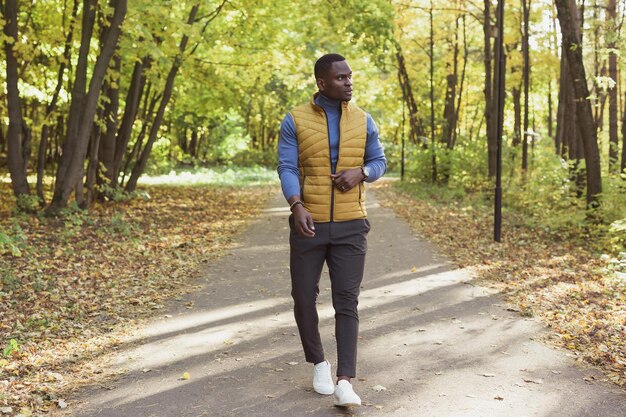 Hipster african american man walking in autumn park