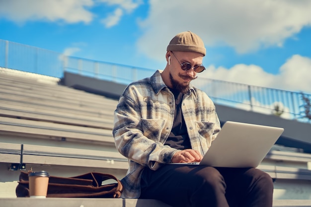 hipster blogger in stylish eyewear typing content text for attract new followers to own website