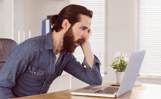 Hipster businessman working on laptop