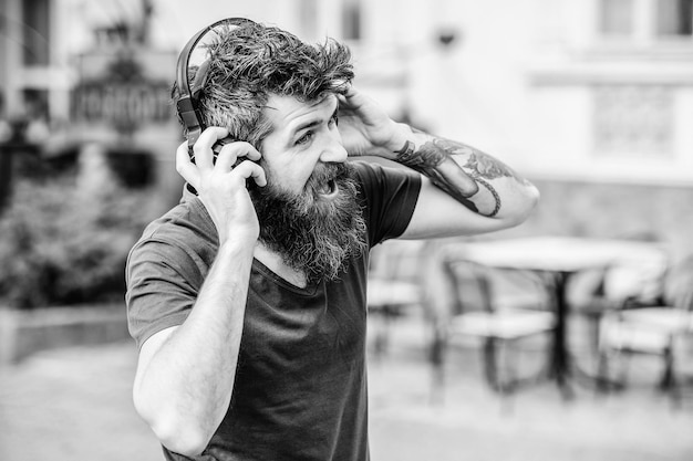 Hipster enjoy excellent sound song in earphones Walking with music Music beat for energetic mood Rhythm for walk Man bearded hipster headphones listening music Excellent music playlist