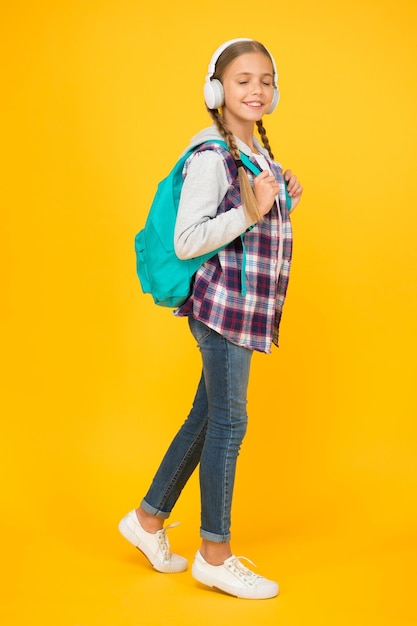 Hipster girl care backpack schoolgirl casual style hold school bag autumn kid fashion child listen music headset childhood education and development happy childrens day audio book