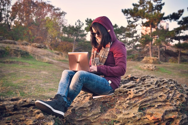 Hipster girl sitting on rock