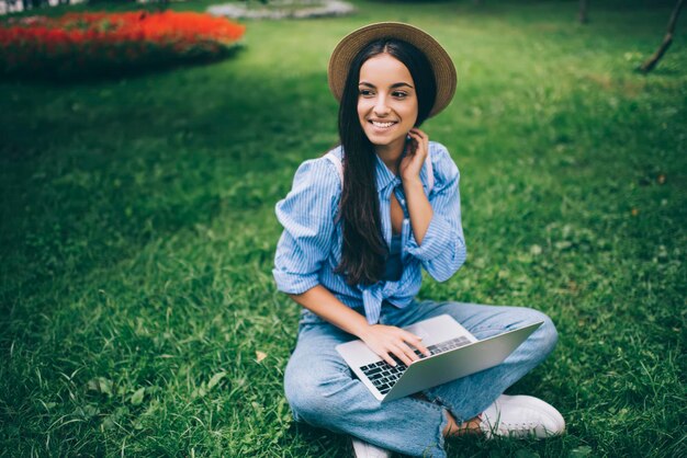 hipster girl taking rest on green grass enjoying free time for online communication