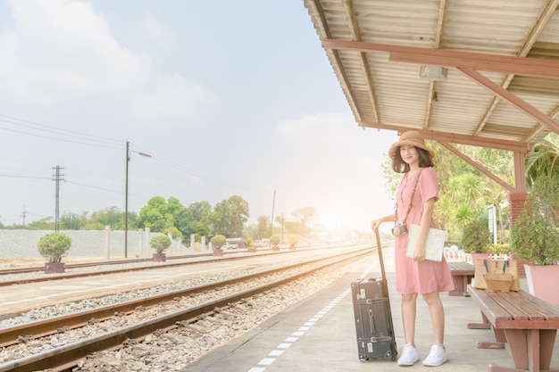 Hipster girl waiting train with leather vintage bag 