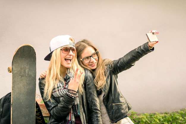 Hipster girlfriends taking a selfie in urban city context