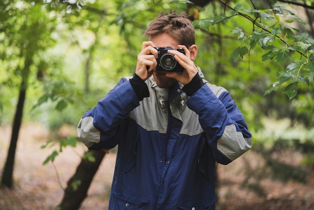 A hipster making photo using old vintage camera outdoors