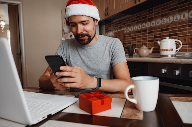 A hipster man with a red cup sitting at home at Christmas time