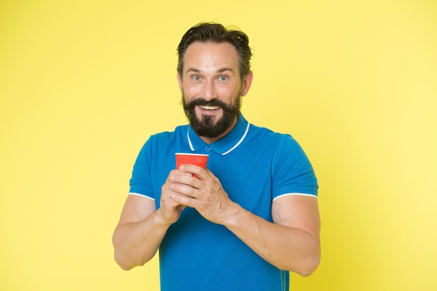 Hipster mature man hold paper coffee cup stand yellow background. Relaxing coffee break. Drink it on the go. Man bearded prefer coffee take away. Eco lifestyle and recycling. Recyclable coffee cup.