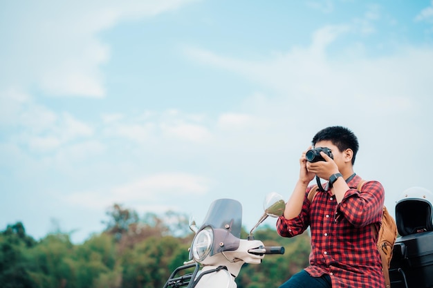 Hipster photographer riding a motor scooter on road Traveled by scooter slow life on vacation resting time