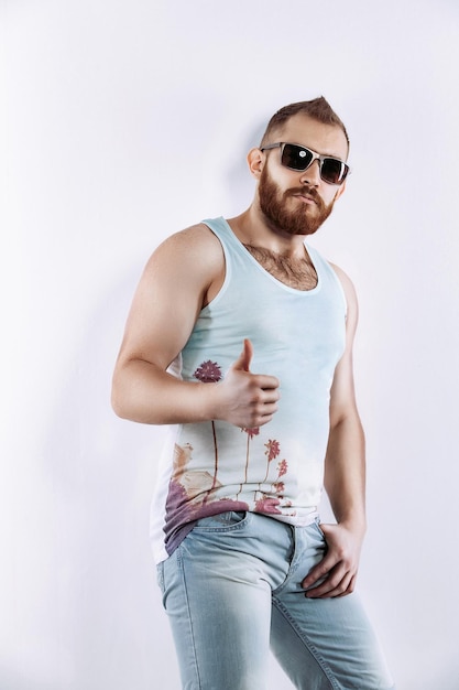 Hipster redhead bearded man in sunglasses in summer clothes showing thumb up on white background