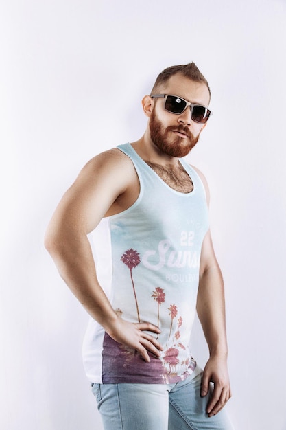 Hipster redhead bearded man in sunglasses in summer looking at camera posing on white background