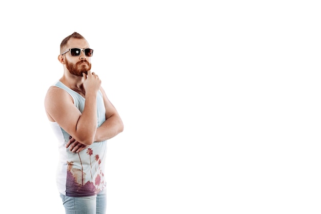 Hipster redhead bearded man in sunglasses in summer posing while standing on white background