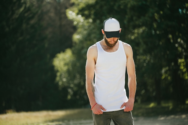 Hipster wearing white blank t-shirt and a baseball cap