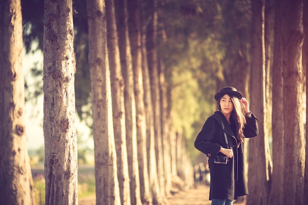 hipster woman taking photo with photo camera on background of Pine tree