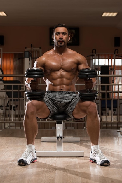 Hispanic Bodybuilder Working Out Shoulders  Dumbbell Concentration Curls