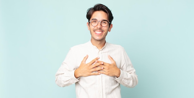 Hispanic handsome man looking happy, surprised, proud and excited, pointing to self