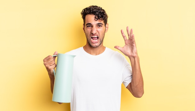 Hispanic handsome man screaming with hands up in the air. coffee thermos concept