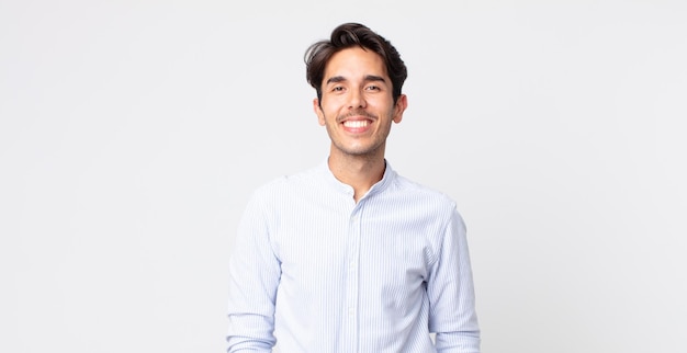 Hispanic handsome man smiling cheerfully and casually with a positive, happy, confident and relaxed expression