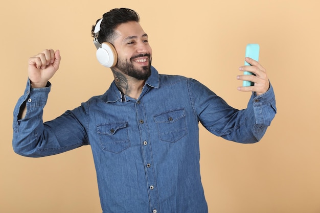 Hispanic latino man takes selfie while listening to music with headphones