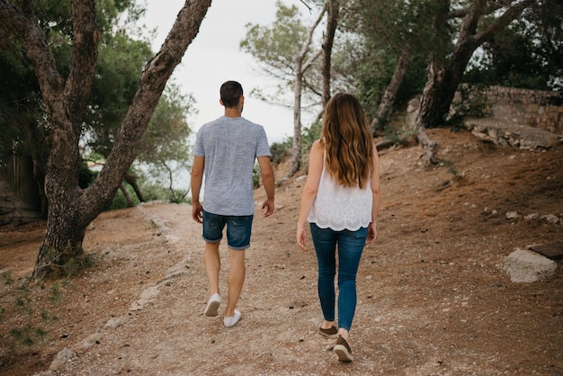 A Hispanic man and his Latina girlfriend are descending from a hill in Spain