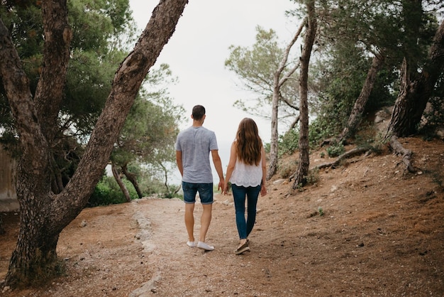 A Hispanic man and his Latina girlfriend are descending from a hill in Spain