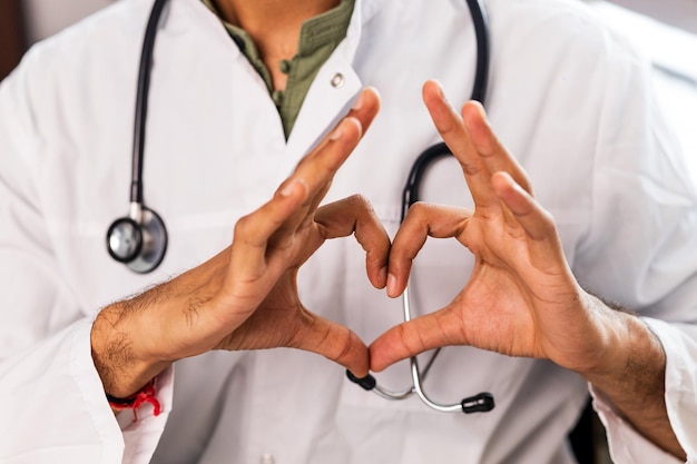 Hispanic medical student in white coat with stethoscope in clinic