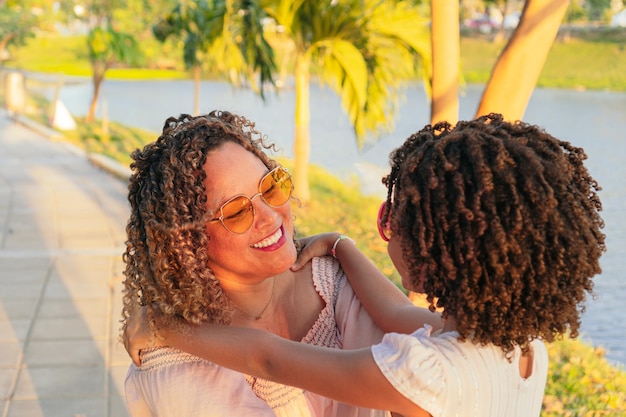 Hispanic mother and her daughter in the park during summer vacations