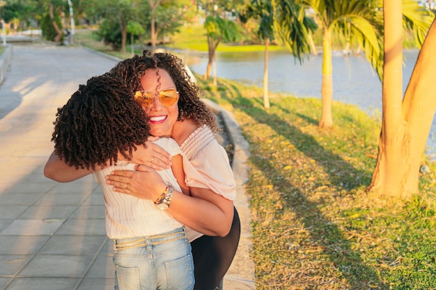 Hispanic mother hugging her young daughter in the park