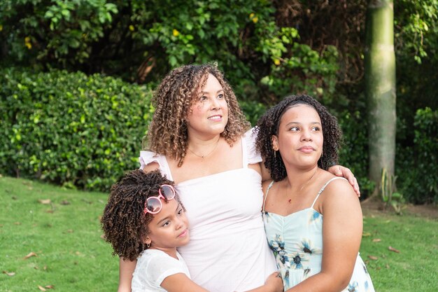 Hispanic Mother with daughters enjoying a sunny day in the park