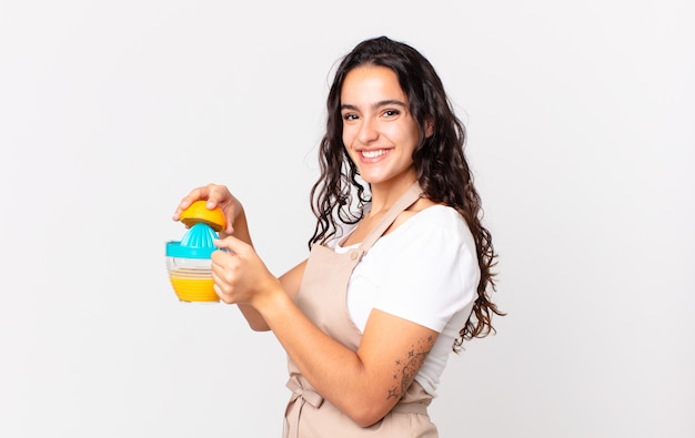 Hispanic pretty chef woman preparing an orange juice