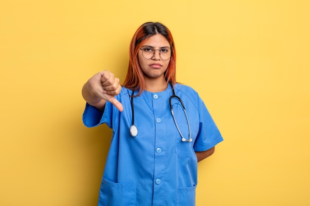 Hispanic woman feeling crossshowing thumbs down nurse concept