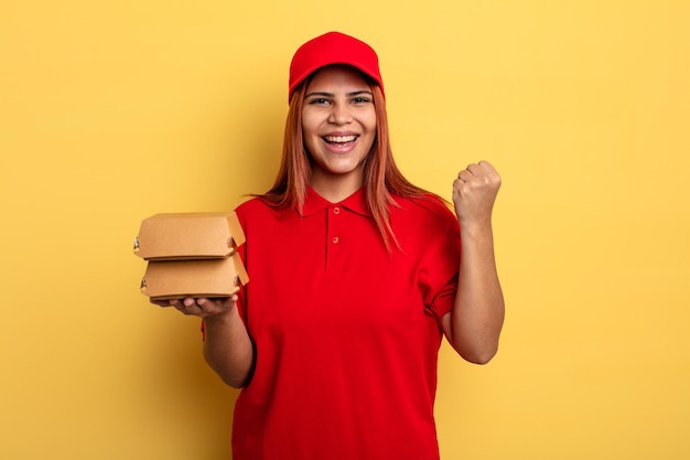 Hispanic woman feeling shocked,laughing and celebrating success. take away deliver concept