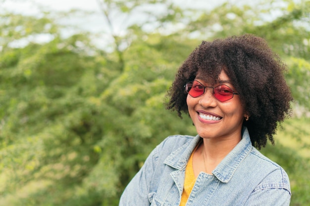 Hispanic woman looking at the camera while posing on a natural background of green plants