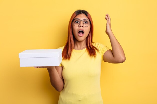 hispanic woman screaming with hands up in the air. empty packaging concept