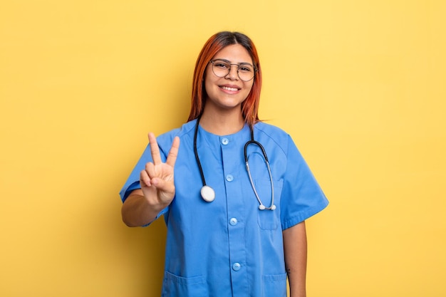 Hispanic woman smiling and looking friendly showing number two nurse concept