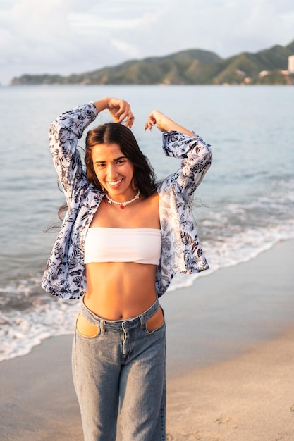 Hispanic woman standing beside the ocean