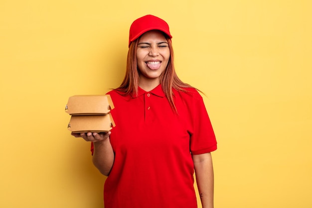 Hispanic woman with cheerful and rebellious attitude, joking and sticking tongue out. take away deliver concept