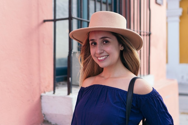 Hispanic woman with hat on her head while standing on the street