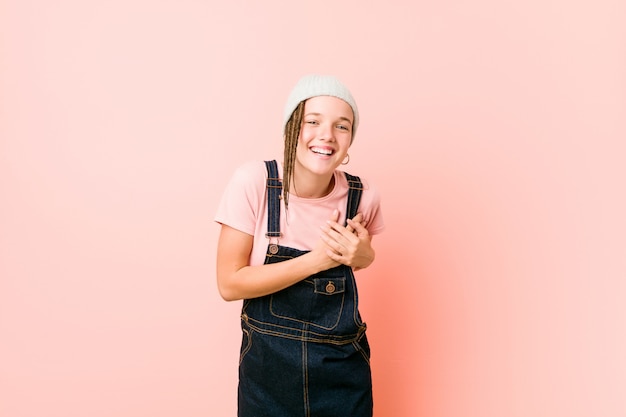 Hispter teenager woman laughing keeping hands on heart, concept of happiness.