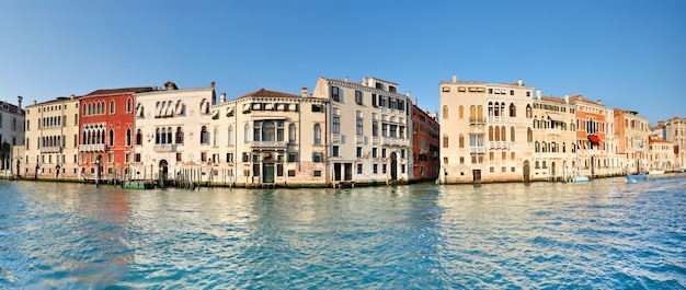 Historic houses on Grand Canal in Venice, Italy. Panoramic image with reflection.