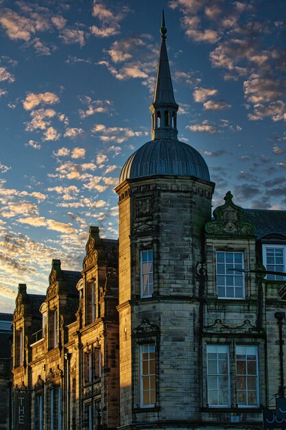 Photo historic stone building with a spire against a dramatic sky with golden sunset clouds in lancaster