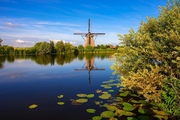 Historic windmill and a river flowing by in Kinderdijk Netherlands