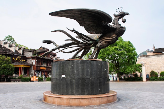 Photo historical immortal bird phoenix statues or heritage feng huang monument for chinese travelers travel visit at xiangxi phoenix ancient city or antique fenghuang old town on may 9 2024 in hunan china